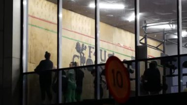 Genç kadınlar, büyük siyah deri topları olan koçla birlikte duvarın yanında.