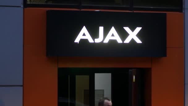 AJAX inscriptie boven ingang. Gloeiende reclame signboard logo boven de deur — Stockvideo