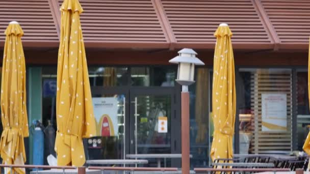 Logotipo da McDonalds num restaurante de fast food. Guarda-chuvas fechados. Reconstrução — Vídeo de Stock