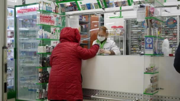 Az idős nő beszél a gyógyszerésszel. Védőmaszkot viselő gyógyszerész — Stock videók