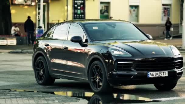 Czarny nowoczesny luksusowy samochód Porsche stoi na ulicy czekając na sygnalizację świetlną — Wideo stockowe