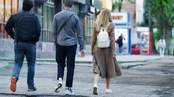 暖かい晴れた夏の日に歩道に沿って友人が歩く。バッグを持った女の子 — ストック動画
