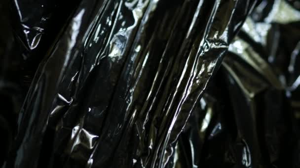 Black plastic wrap. Polyethylene bag. Crumpled vinyl. Dark stretch film package — Stock Video