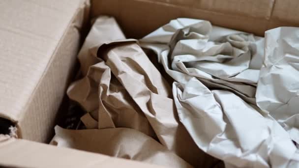 Pacote aberto. Material de embalagem para dentro. Papel enrugado para proteger artigos frágeis — Vídeo de Stock
