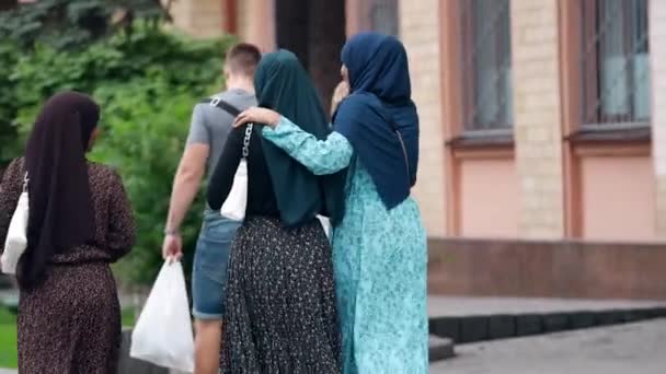 Bedrijf van vrolijke jonge vrouwen in traditionele moslimjurk loopt door de straat — Stockvideo