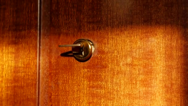 A kulcs a kulcslyukban van. A kulcs a régi szekrény ajtaján van. Lakkozott fa — Stock videók
