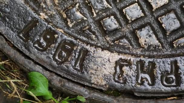 The cast iron water manhole cover is wet after a summer rain. Old vintage hatch — Stock Video