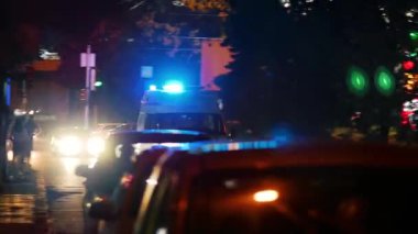 Geceleri şehrin caddesinde koşuşturan, yanıp sönen fenerleri olan bir ambulans