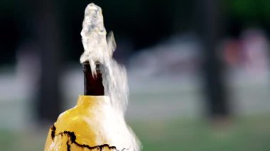 Yazın çeşmeden su akar. Demir üzerine beyaz boya soyuluyor.