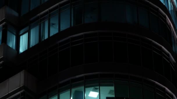Офисное здание летней ночью. Высотный современный бизнес-центр с включенными огнями — стоковое видео