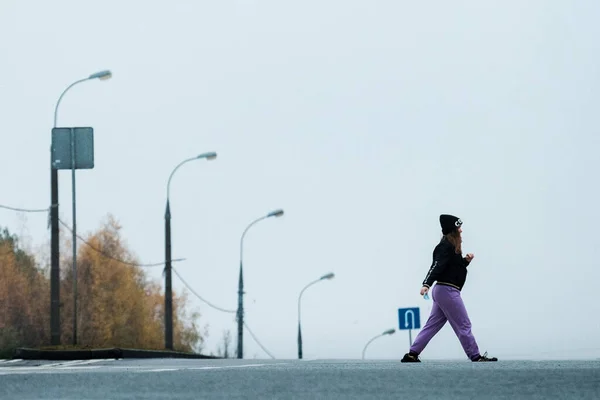 MOSCOW, Oroszország - NOVEMBER 02 2020: Egy maszkos lány átkel a Yasenevóba vezető úton — Stock Fotó