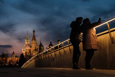 MOSCOW, RUSSIA - 17 Nisan 2021: İnsanlar Zaryadye Parkı 'nda akşam saatlerinde akıllı telefonla fotoğraf çekiyor