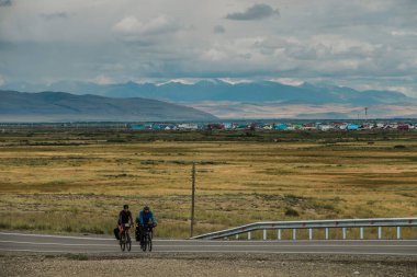 KOSH-AGACH, RUSSIA - AĞUSTOS 07 2021: Chuisky karayolu boyunca bisiklet süren turistler