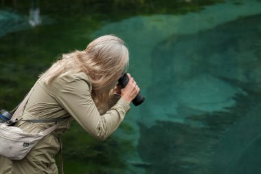 Dürbünlü kız Altai Cumhuriyeti dağlarında duruyor..