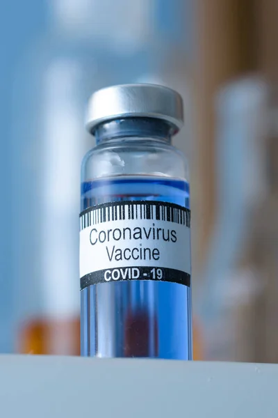 Coronavirus aşısı şişede. Arka plandaki tıbbi laboratuara karşı yapılacak enjeksiyon için. SARS-CoV-2 koronavirüs salgınını yenmek. Bilim adamları koronavirüse karşı aşı buldular.