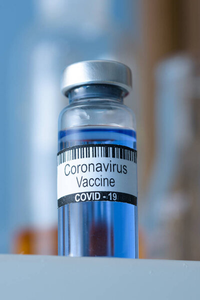 Coronavirus vaccine in bottle for injection on table against background medical laboratory. Defeating SARS-CoV-2 coronavirus epidemic. Scientists have found vaccine against coronavirus