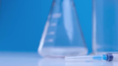 Küresel tehlike 2019-Ncov için tıbbi aşı. Şişe içinde Coronavirus aşısı. Laboratuvar masasının mavi arka planına yakın plan. Covid-19 salgınına karşı ilaç. Coronavirus 'a karşı zaferi kabul et