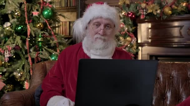 Svatý Mikuláš online přeje všem šťastný nový rok a veselé Vánoce. Starý Santa Claus komunikuje přes notebook přes video chat s dětmi na dálku. Blahopřejeme dovolená v síti Satna. — Stock video