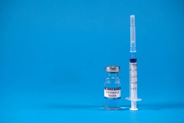 Cam ilaç şişesinde Coronavirus covid-19 aşısı icat edildi. Mavi zemin üzerinde metin için yer olan şırınga. Sars-nCoV-2 salgınına karşı zafer kavramı. Virüs 2019-nCoV yenildi