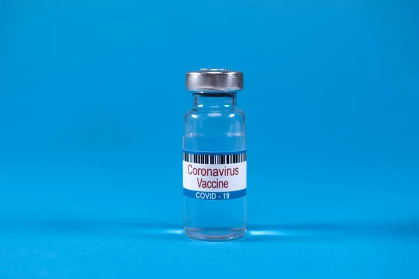 Victory over SARS-nCoV-2 coronavirus epidemic. Scientists have found vaccine against SARS-nCoV-2 coronavirus. Coronavirus vaccine in glass medicine bottle on blue background with space for text.