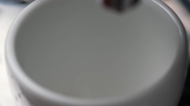 Sıcak aromatik espresso kahvesi yapmak için yakın çekim. Sıcak kahve, yüksek su basıncı altında kahve makinesinden beyaz fincana akar. Barista canlandırıcı bir sabah için lezzetli bir kahve hazırlar.