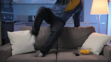 Zor günlerden sonra rahatla. Adam buzdolabından bira alıyor, kanepeye zıplıyor, birayı açıyor ve TV 'yi açıyor ve akşamları evde televizyon seyrediyor..