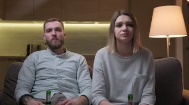 Futbol maçı izlerken hayal kırıklığı ve öfke duyguları, TV izlerken en sevdiğiniz takımı kaybetmeniz. Genç çift TV 'de oturmuş, sporda talihsiz bir olaya duygusal tepki veriyor..