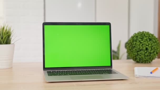 Ordenador portátil moderno con pantalla verde de croma simulada en la mesa de la sala de estar, escritorio configurado para el trabajo en casa - concepto de tecnología de cerca. — Vídeo de stock