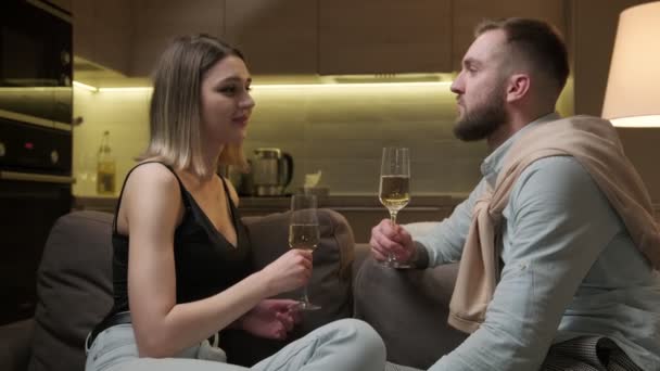 Verliefd stel met een glas mousserende wijn, feestelijk afspraakje, champagne drinken, in een romantische sfeer thuis. Toast, vakantie groet concept, Valentijnsdag. — Stockvideo