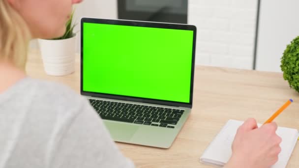 Kvinna lyssnar på online-föreläsning i videokonferens på laptop, grön skärm på bärbar dator för chroma nyckel teknik, detalj visa — Stockvideo