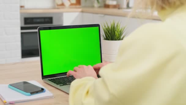 Flicka använder grön skärm chroma nyckel laptop för att lära, skriver ner användbar information. distansutbildning, e-utbildning, e-lärande, hemskolekoncept. närbild över axeln POV. — Stockvideo