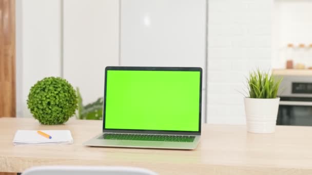 Moderner Laptop mit Chroma-Key-Attrappe, grüner Bildschirm auf Wohnzimmertisch, Schreibtisch für die Arbeit zu Hause eingerichtet - Technologiekonzept hautnah. — Stockvideo