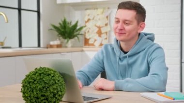 Genç adam konferans görüşmelerini bilgisayarla, öğrenci çalışmalarını internetteki bir öğretmenle konuşuyor. İç işlerindeki video konferansında dizüstü bilgisayarlı sohbete bakın..