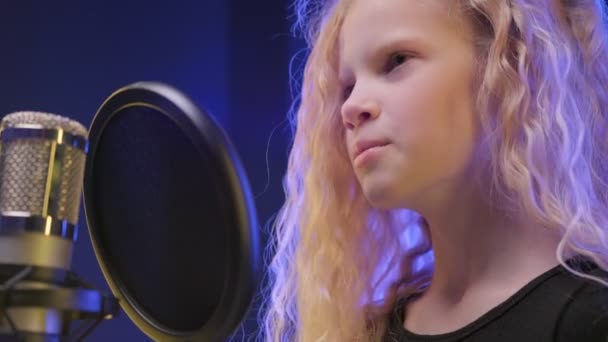 Portræt professionel sanger udfører sang synger ind mikrofon i lydstudie. Ung blondine pige i lydstudie synger sang i professionel mikrofon og poster sang. – Stock-video