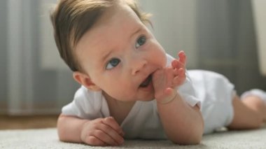 Sevimli yeni doğmuş bebek kız karnının üzerine yatar ve parmaklarını ağzıyla ısırır. Childs 'ın dişleri büyür, çocuk ağzındaki diş etleriyle parmaklarını ısırır. Sevimli kız ayağa kalkıp emeklemeye çalışıyor..