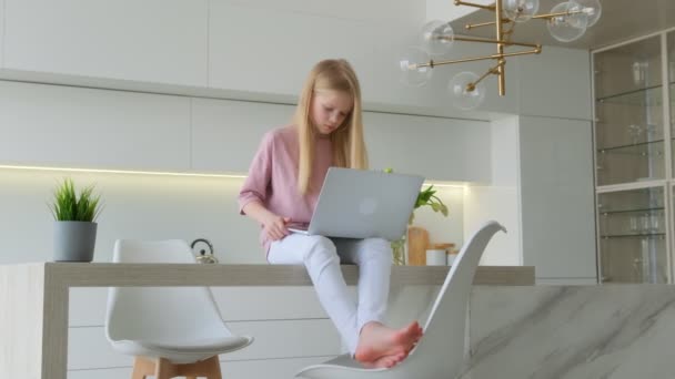 Menina feliz conversando no computador navegando Internet redes sociais estudando ou trabalhando on-line em casa. Sorrindo jovem sentada na mesa usando laptop olhando para a tela notebook digitação mensagem — Vídeo de Stock