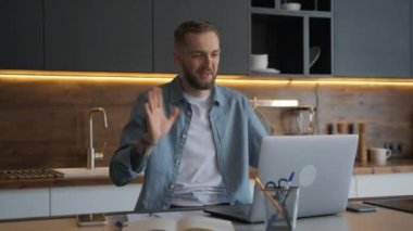 Genç ve mutlu bir erkek öğrenci evde bilgisayar kullanarak video eğitimi hakkında konuşuyor. Röportajda traşsız bir iş adamı, internette ekiple konuşuyor. Uzak çevrimiçi iş kavramı.