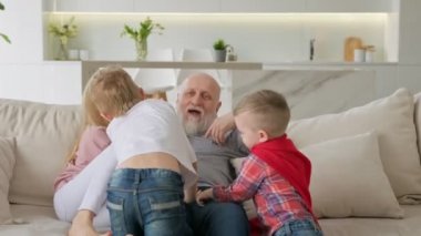 Mutlu emekli büyükbaba torunlarıyla dinleniyor, çocuklar büyükbabalarına sarılıyor, eğleniyor ve gülüyorlar. Ailesi olan yaşlı bir insanın tasasız emekliliği kutlu olsun..