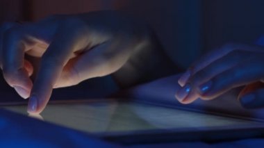 Dokunmatik ekranlı tablet aygıtını kapat, kız elleriyle metin mesajı yazıyor, parmaklarıyla ekranı kaydırarak İnternet 'te resim ve haber arıyor.