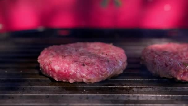 Delicious burger with barbecue grill. Cooking on barbecue grill. Juicy two cutlets beef burgers are fried over high heat on bbq grill with sparks of ash and flame. Cooking hamburger picnic on street. — Stock Video