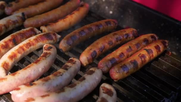 Närbild Juicy nötkött korv kokas över en öppen eld i sommarväder. Grillat fläsk och nötkött korv kokas över varma grillkol, picknick i soligt sommarväder. — Stockvideo