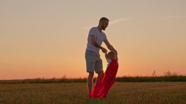 Mutlu, güçlü bir aile babası ve oğlu gün batımında çayırlarda el ele tutuşuyorlar. Güçlü aile babası ve oğlu, güçlü aile ve aile ilişkileri kavramı.