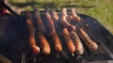 Kömürün üstünde et hazırlıyor. Festivalde taze ızgara yemek. Yemek bölümleri. Yakın plan. Kızarmış ve tütsülenmiş ızgara yemek. Yaz havasında barbekü ızgarasında et ve domuz etinden yapılmış ev yapımı sosisler..