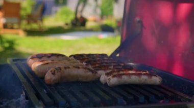 Street Food Market 'teki Grill' de sosisler hazır. Sokak mutfağı. Barbekü partisi. Kömürün üstünde et hazırlıyor. Festivalde taze ızgara yemek. Yemek bölümleri. Yakın plan. Kızarmış ve tütsülenmiş yemek..