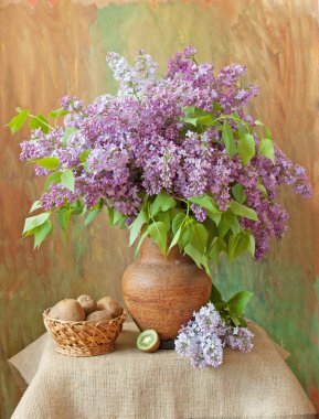 Hayat bir demet leylak ve patates ile masada bir kasede