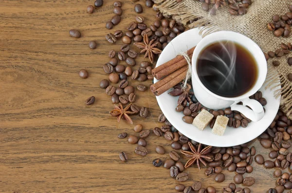 用肉桂棒和茴香在木制背景上的咖啡 — 图库照片