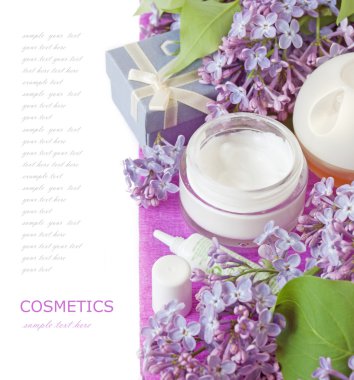 Hediye kutusu ve beyaz arka planda leylak çiçeği olan kozmetik kavanozu.