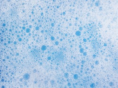 Beyaz arkaplanda mavi sudaki sabun köpüklerini kapat