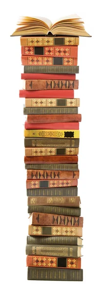 Pila de libros antiguos de color sobre la mesa y uno abierto sobre un fondo verde — Foto de Stock