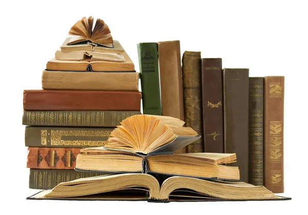 Pile of old color books on the table and one open on a green background — Stock Photo, Image